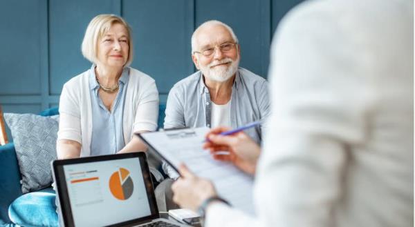 A retired couple meets with their financial advisor to talk a<em></em>bout their income plan.